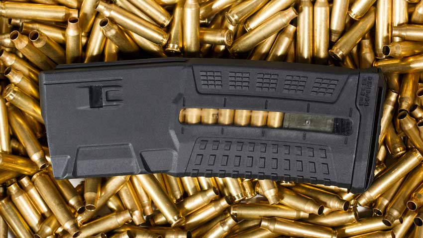 AR15 magazine laying on top of a bed of empty casings