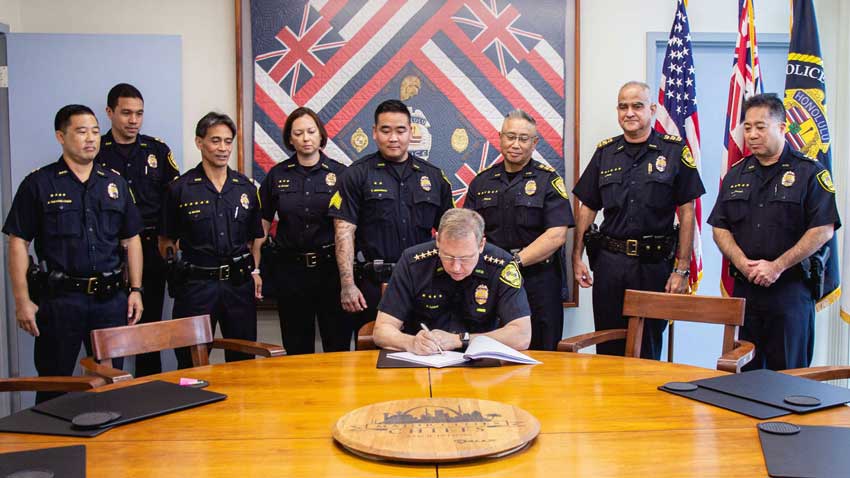 Police gathered around chief signing first carry permit in Oahu, Hawaii