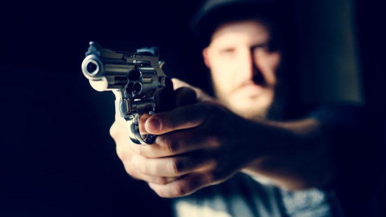 Image of a man pointing a revolver