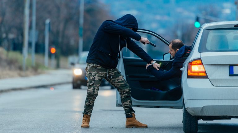 A carjacker carjacking a victim.