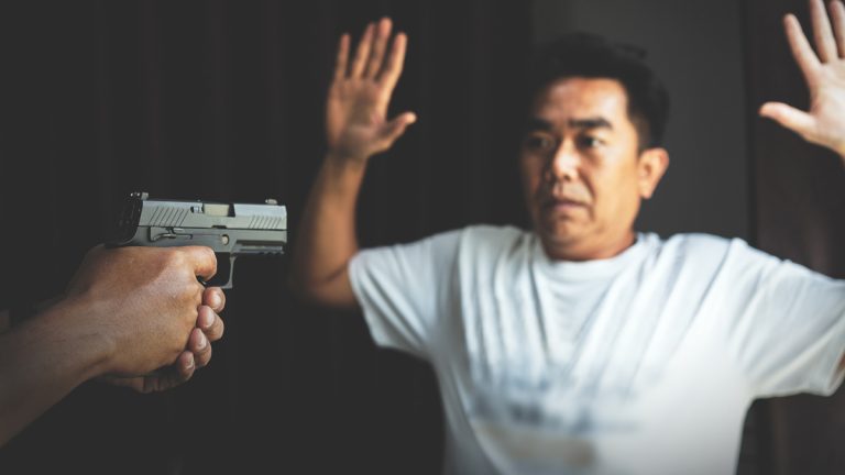 A man being robbed at gunpoint