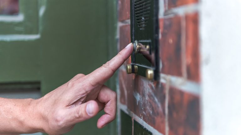 A person ringing a doorbell