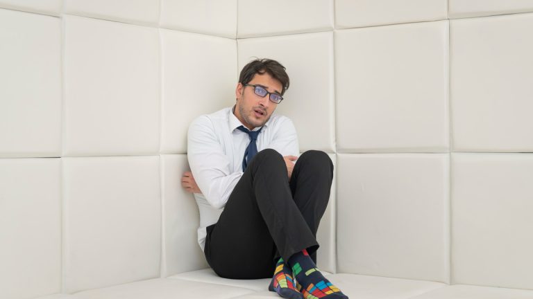 Man in padded room at mental institution