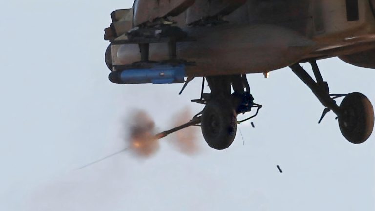 A helicopter firing an M230 machine gun