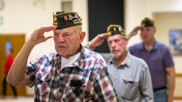 Elderly military veterans saluting