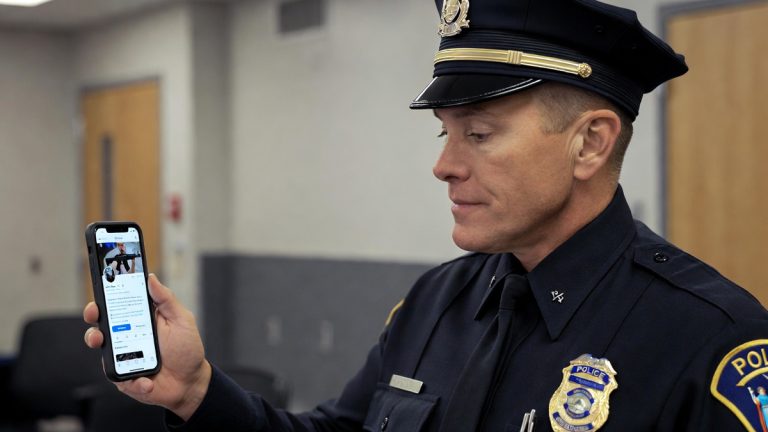 A police officer looking at a social media profile