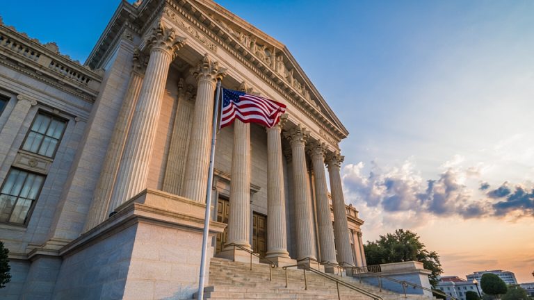 A courthouse with an American flag flying in front of it