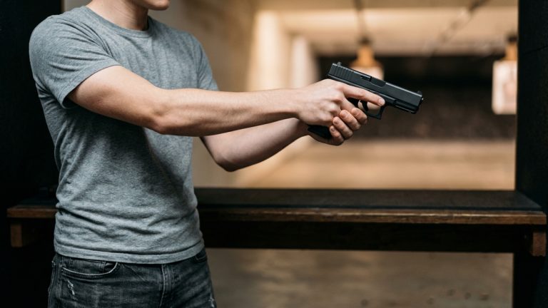 A young person holding a handgun