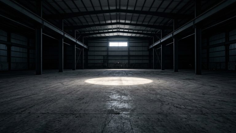A dark warehouse with a light shining on the floor